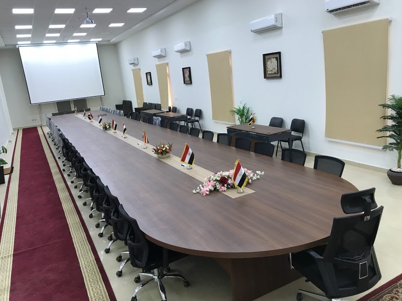 طاولة اجتماعات تنفيذية ضخمة بتصميم بيضاوي ومجاري كهرباء مدمجة لتجهيز المقرات الإدارية والشركات